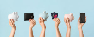 Female hands with piggy banks, credit cards, wallet and mobile p