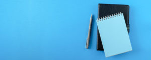 notebook and pen on blue screen