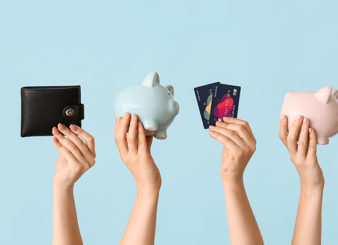 Female hands with piggy banks, credit cards, wallet and mobile p